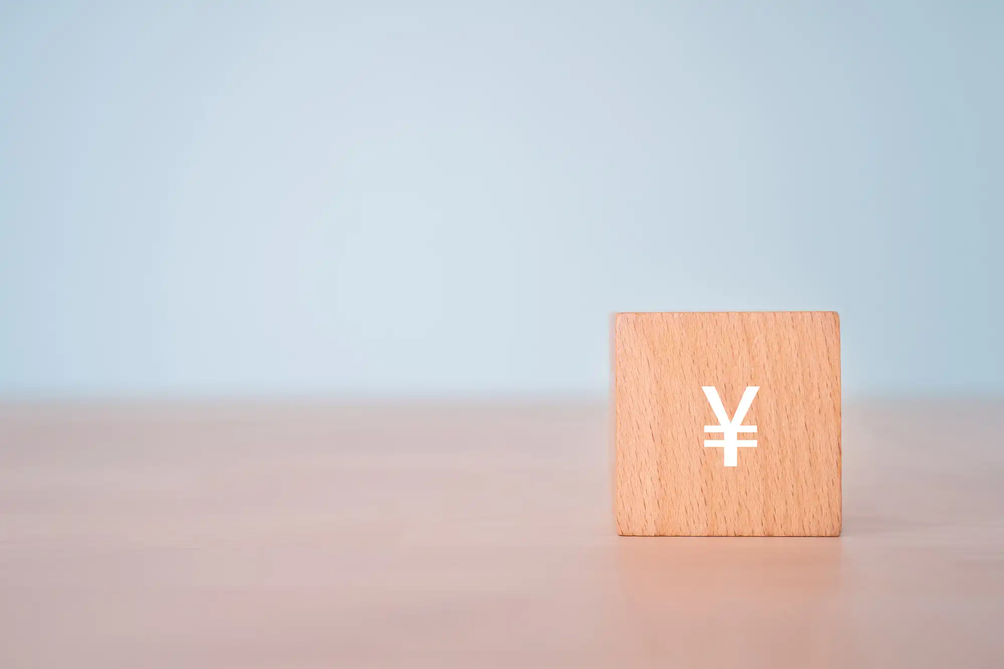 ¥マークが書かれた積み木が机の上に置かれている