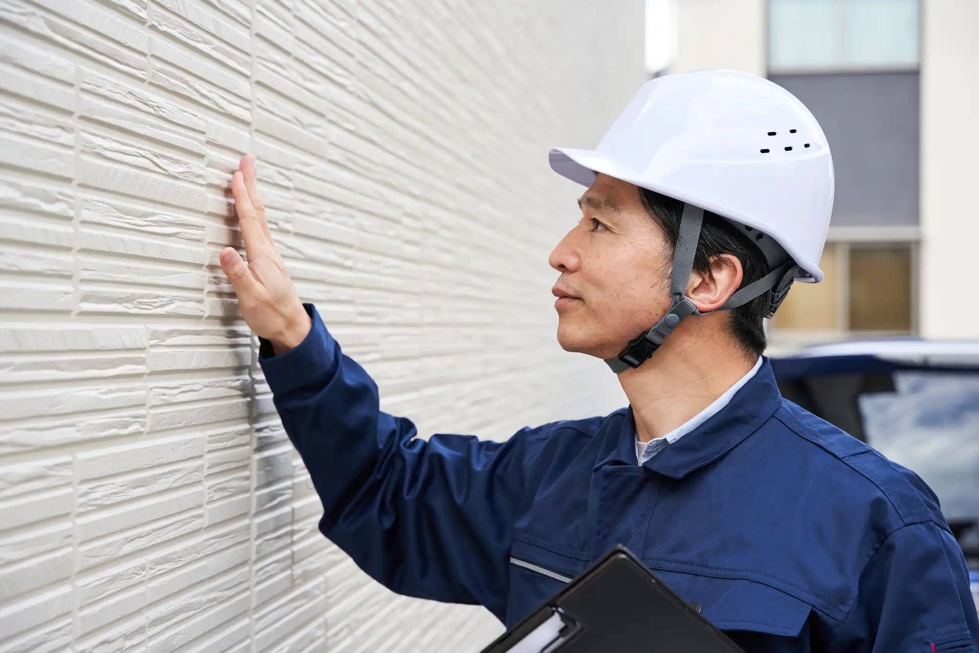 外壁の様子をチェックする作業員