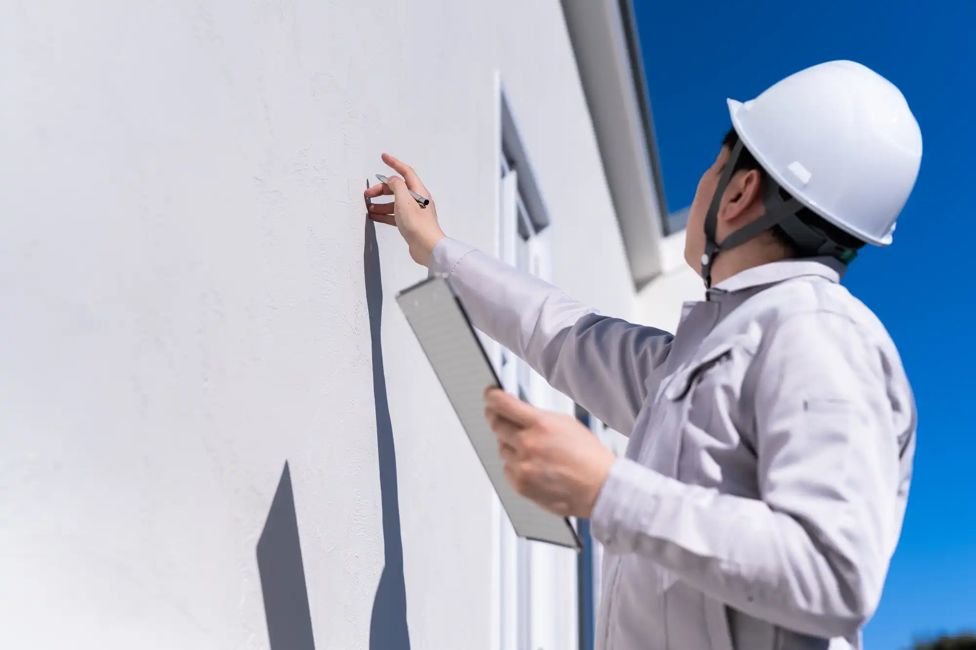 壁をチェックする作業員